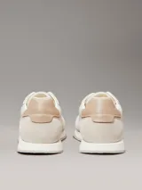 Zapatillas Calvin Klein de perfil bajo, confeccionadas en una combinación de ante, piel y lona en tonos beige. Presentan un diseño minimalista con suela de caucho y logo de la marca estampado en el lateral.
