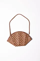 Cartera de mano con forma de hoja, confeccionada en cuero trenzado color naranja y negro. Asa corta trenzada de cuero negro.