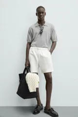 Bermuda de algodón color beige claro, de corte regular fit, con cintura elástica ajustable mediante cordón. Presenta bolsillos laterales y un bolsillo trasero de vivo.