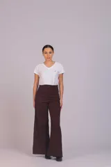 Pantalón de corte wide leg confeccionado en pana acanalada color marrón chocolate. Presenta tiro alto, cierre frontal con botón y bolsillos laterales.