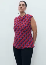 Blusa sin mangas con cuello drapeado, confeccionada en tejido fluido con estampado geométrico en tonos rojos y violetas.