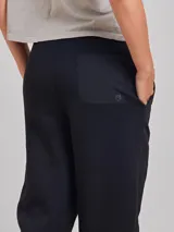 Babucha de estilo deportivo en color negro, confeccionada en tejido ligero con acabado texturizado. Presenta cintura elástica con cordón ajustable y corte holgado.