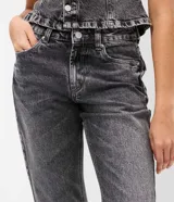 Pantalón de jean con corte flare, tiro medio y efecto desgastado. Presenta cierre frontal con botón, pasantes para cinturón y bolsillos traseros con solapa.