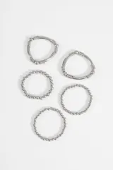 Set de cinco pulseras elásticas de diseño minimalista en color plateado, compuesto por piezas de diferentes grosores y texturas de cuentas metálicas.