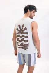 Musculosa verde agua con gran estampado en la espalda de un sol y olas en tono marrón.