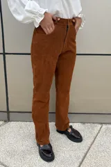 Pantalón de cuero ovino italiano color crema, de corte recto con tajos laterales en el ruedo.