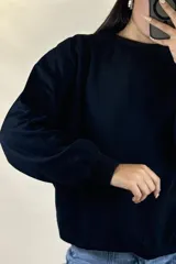 Buzo de cuello redondo, corte oversize, con mangas largas y puños elásticos.