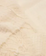 Fular color beige de textura gofrada con terminación de flecos en los extremos.
