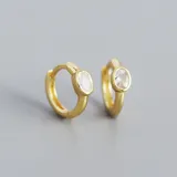 Par de aros dorados tipo argolla con un cristal ovalado engarzado.