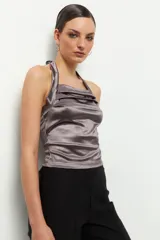 Top negro de satén con cuello halter y espalda descubierta.