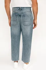 Pantalón de jean gris oscuro, ancho y de tiro medio.