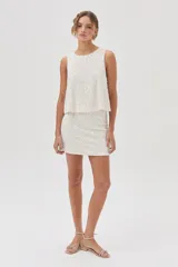 Top de lentejuelas color blanco, sin mangas y con espalda cruzada.