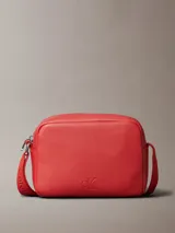 Bolso bandolera rojo de cuero sintético con monograma CK grabado en el frente y correa ajustable con el logo de Calvin Klein.