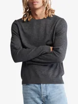 Sweater gris de punto liso, con cuello redondo y mangas largas. Tiene el logo de Calvin Klein bordado en el pecho.