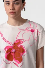 Remera color crudo de algodón con cuello redondo y mangas cortas. Estampa exclusiva "Flower Market" con flores en tonos rosa y marrón.