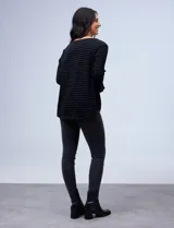 Blusa negra texturada de poliéster y elastano, con mangas 3/4 acampanadas y cuello redondo.