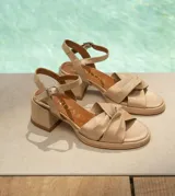 Sandalias de cuero color dorado, con plataforma y taco cuadrado. Presentan tiras cruzadas en el empeine y pulsera al tobillo con hebilla.