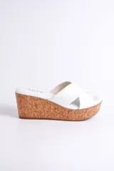 Sandalia blanca con plataforma de corcho y tiras cruzadas de cuero.