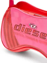 Bolso de hombro Diesel Play para mujer, con silueta inspirada en un mando de videojuego y estilo moto. Hecho de PU brillante con bloques de color rojo y rosa, parches de logotipo aplicados y placa de metal con el logotipo Oval D.