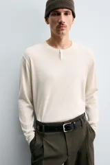 Jersey de punto con mezcla de algodón y cashmere, de corte regular y manga larga. Presenta cuello redondo con cierre frontal de dos botones y acabados en rib.