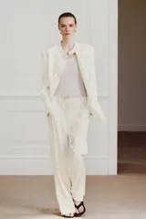 Pantalón de tiro medio de ZARA Woman Collection confeccionado en hilatura de viscosa. Cuenta con cintura con trabillas, bolsillos laterales, raya planchada y pierna recta con bajo asimétrico y aberturas. Cierre frontal con cremallera, botón y ganchos metálicos.