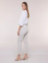 Pantalón color beige de corte entallado y largo cropped, confeccionado en tejido de punto con elasticidad técnica. Cuenta con pretina ancha y plana, bolsillos simulados al frente y bolsillos tipo ojal en la parte posterior.