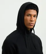 Campera deportiva con capucha y cierre de cremallera frontal, de color marrón. Cuenta con bolsillos laterales con cierre y puños y cintura elastizados.