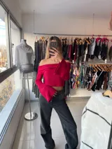 Top de punto fucsia con escote off-shoulder y mangas largas acampanadas.