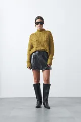 Minifalda de cuero sintético con corte en A y diseño minimalista.