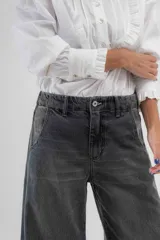 Pantalón de jean de tiro medio y pierna ancha, confeccionado en denim 100% algodón. Diseño con 5 bolsillos y pespuntes a contratono.