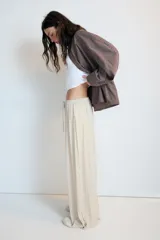 Pantalón de tiro medio, color negro, confeccionado en tejido satinado con diseño de pierna ancha y cintura elástica ajustable con cordón.