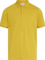 Chomba color mostaza de corte slim, confeccionada en algodón orgánico. Tiene cuello clásico con dos botones, mangas cortas con puños de punto, aberturas laterales y logo tonal de Calvin Klein bordado en el pecho.