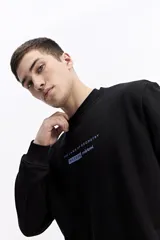 Buzo negro de algodón con cuello redondo, puños y cintura elásticos. Presenta un pequeño estampado frontal con texto en azul claro.