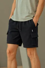Bermuda cargo de tejido waffle en color negro, con cintura elástica con cordón de ajuste y bolsillos laterales con solapa.