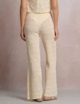 Pantalón de tiro alto con tejido calado y textura labrada, de corte recto con apertura acampanada hacia el ruedo. Cuenta con cintura elastizada y cordón de ajuste con terminaciones de caracoles decorativos.