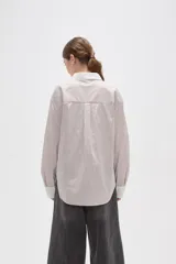 Camisa de lyocell con estampado de rayas verticales en tonos beige y blanco, corte holgado, cuello clásico y puños anchos en color blanco sólido.