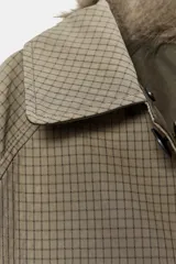 Trench reversible con estampado a cuadros en tonos beige y marrón, con cuello solapa y aplicación de efecto pelo extraíble. Cierre frontal con botones.