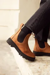 Botas de cuero negro con elástico a los lados, suela de cuero y forro de cuero vacuno.