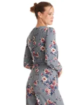 Enterito de crepe con estampado floral, escote en V, mangas largas con puños abotonados y lazo de ajuste en la cintura.