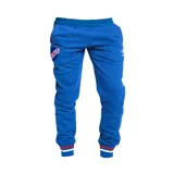 Pantalón de jogging azul con cintura elástica, bolsillos laterales y puños ajustados. Presenta el escudo del Club Nacional de Football en el muslo izquierdo y el logo de Umbro en el muslo derecho.