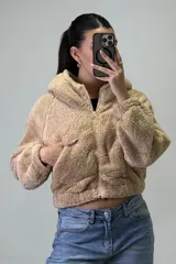 Canguro de peluche con capucha, cierre frontal completo y bolsillos laterales. Diseño de corte corto y textura suave.