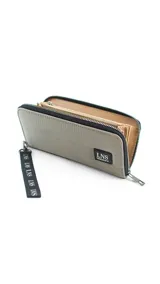 Billetera larga con cierre perimetral y diseño capitoneado. Cuenta con correa de mano desmontable con logo estampado y parche frontal con marca LNS. El interior incluye múltiples compartimentos para tarjetas y un bolsillo con cierre.