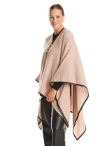 Ruana de tejido soft color beige, con escote en V, cierre frontal con botones metálicos y bordes ribeteados en cuero sintético negro.