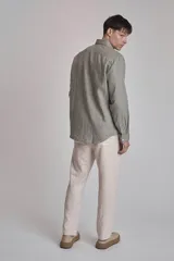 Camisa blanca de lino con cuello abotonado, manga larga con puños abotonados y corte clásico.