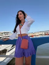 Bandolera pequeña tipo porta celular, color verde claro, confeccionada en cuero sintético. Cuenta con cierre principal, bolsillo frontal con tapa y broche a presión, y correa ajustable extraíble.