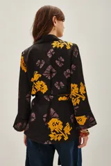 Saco tipo kimono de satén negro con estampado floral en tonos violeta y amarillo, con lazo ajustable en la cintura y mangas largas.