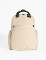 Mochila color beige de cuero vegano con doble compartimento, bolsillo delantero y bolsillos laterales.