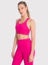 Top deportivo de soporte medio color fucsia, con espalda estilo nadador que presenta detalles de encaje en los tirantes. Incluye sujetador integrado y almohadillas removibles.