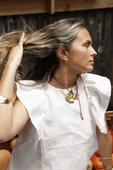 Blusa negra de lino con volados en los hombros y pespuntes en color beige.