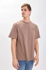 Camiseta manga corta oversize color visón con estampa de escorpión y texto "Poison Club Sting of Power 073 for the true ones only" en la espalda.